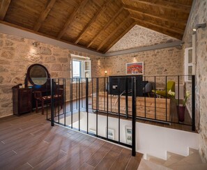 Experience the rustic charm of this room with exposed beams, stone walls, and a wooden floor.