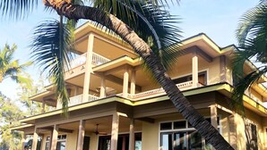 A two-story building with a balcony, large windows, and a covered outdoor seating area. - Spend some time on Puako Beach. (Waimea)