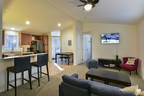 Cozy living space with a kitchenette, dining area, and seating area featuring a TV and couch.
