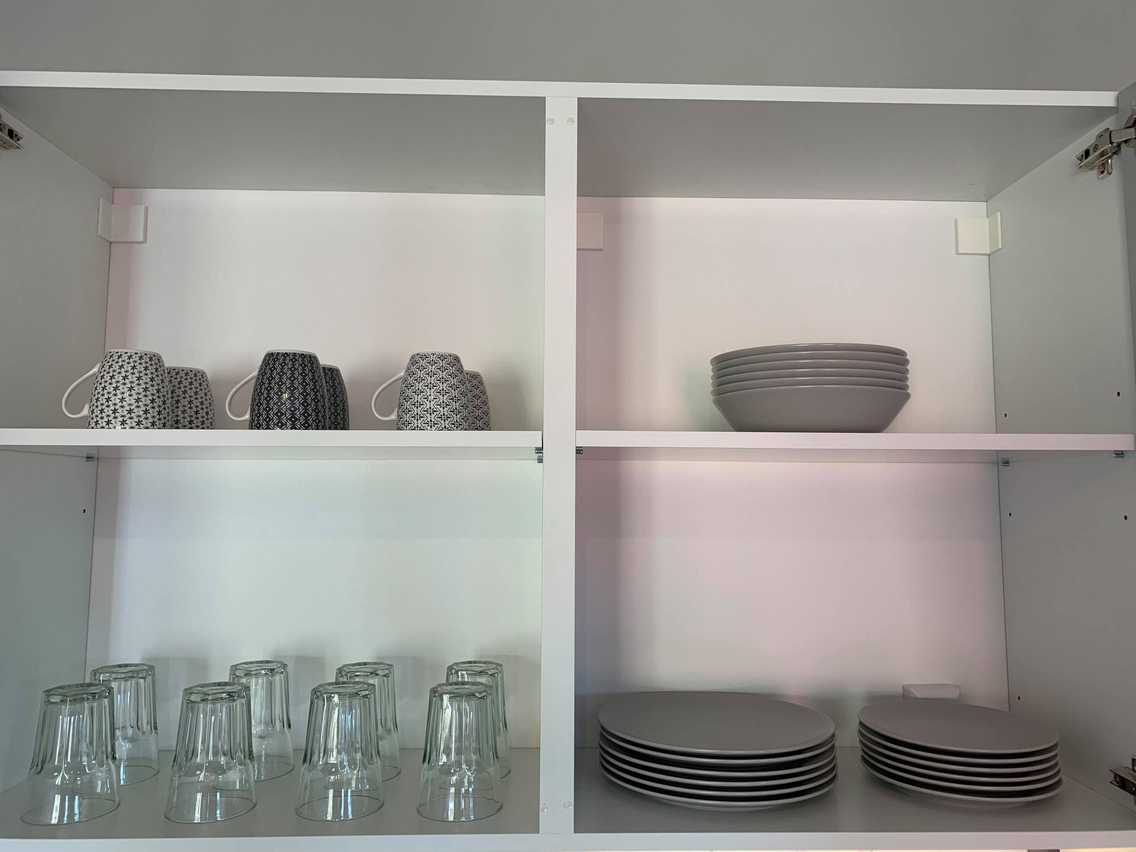 A kitchen with white cabinets, a microwave, and a sink.