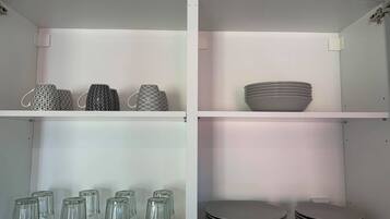 A kitchen with white cabinets, a microwave, and a sink.