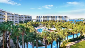 A resort with multiple-story buildings, a central swimming pool, and palm trees. - Destin West Osprey 506 ~ Breathtaking Bay Views ~ Lazy River (Fort Walton Beach)