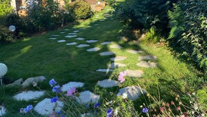 Ein Gartenweg, der zu einem Haus mit Meerblick führt.