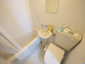A bathroom with a bathtub, sink, toilet, and various toiletries. - STAY IN SUMUKA Shintoshin (Naha)