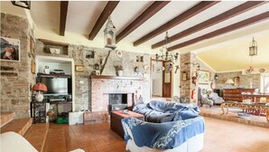 A rustic living room with exposed brick walls, a fireplace, and a cozy seating area. - Casale Gli Angeli - Villa with Garden and Parking (Gubbio)