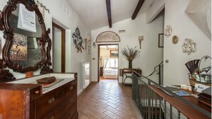 A hallway with a wooden dresser, a large mirror, and a staircase leading to another room. - Casale Gli Angeli - Villa with Garden and Parking (Gubbio)