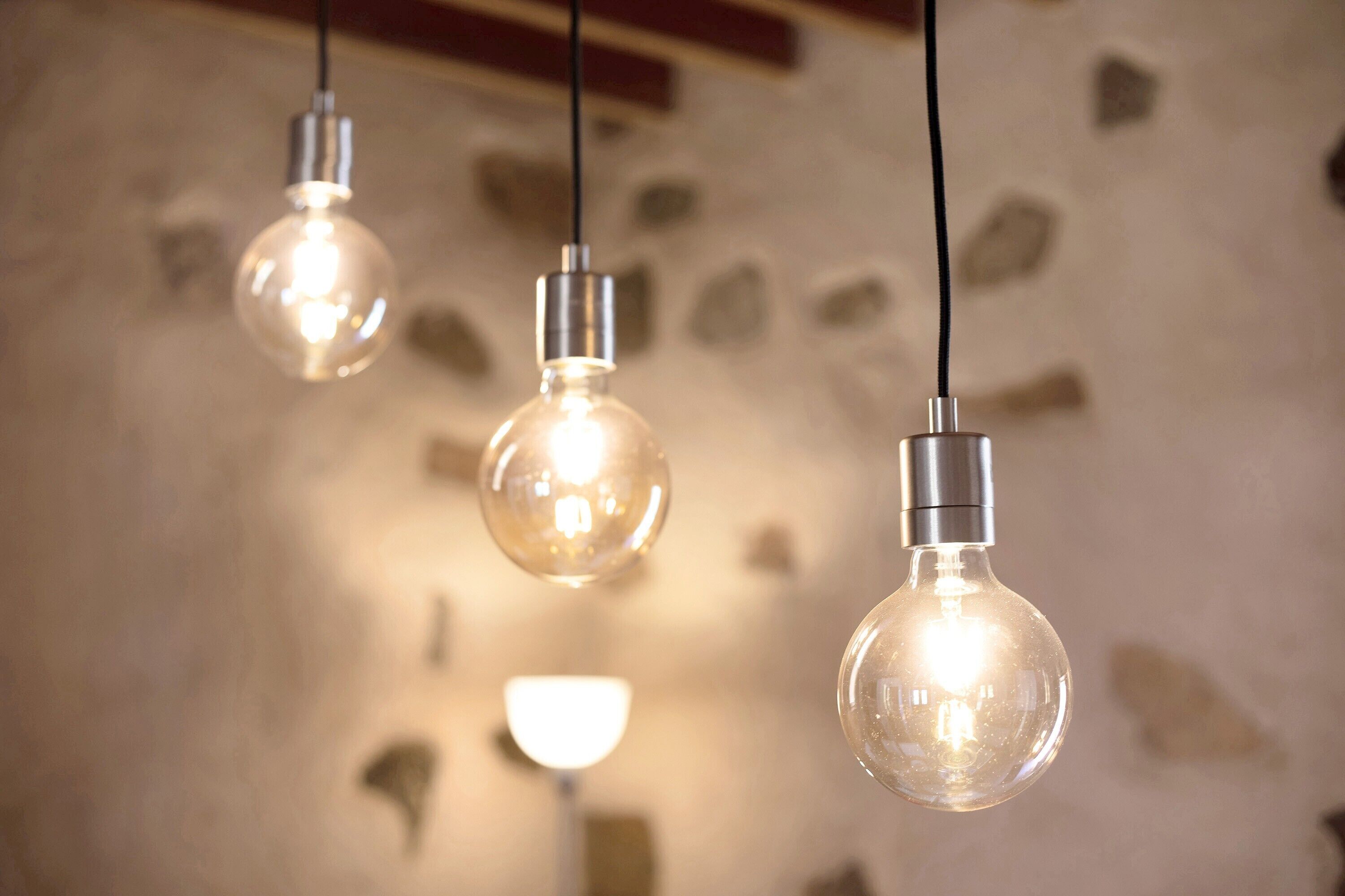 Three hanging light bulbs with visible filaments.