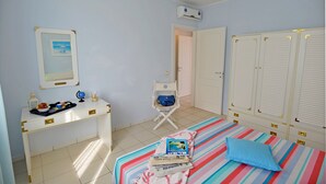 Une chambre à coucher avec un lit, un bureau, une chaise et une armoire.