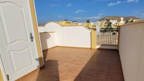 Ein Balkon mit Fliesenboden und einer weißen Tür.