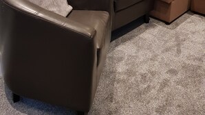 A living room with a brown leather sofa, a brown armchair, and a beige sectional sofa. There are two wall-mounted lights and a power outlet on the wall. - Impeccable 2-Bed Apartment in Blackpool (Blackpool)