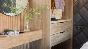 A wooden vanity with a mirror, a vase with bamboo, and a hanging garment. - LUX&EASY Athens Downtown Apartments (Athens)