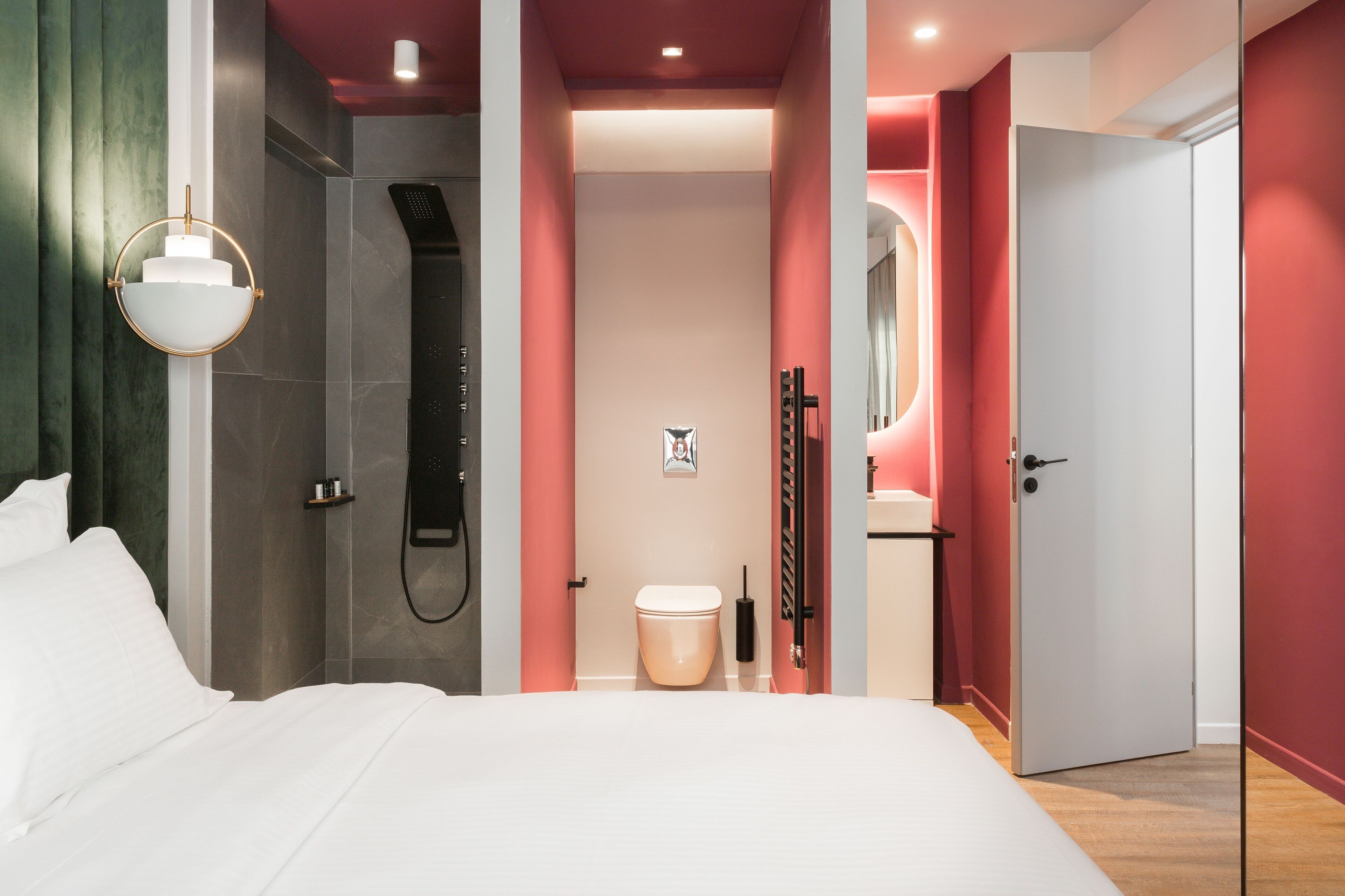 Un dormitorio moderno con una cama grande, ducha y baño con inodoro y lavabo.