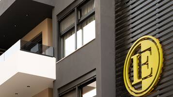 A building facade with a prominent golden 'E' logo, large windows, and a modern architectural design.