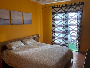 A bedroom with a bed, a nightstand, and a wall-mounted TV.