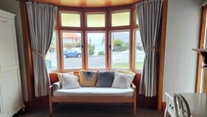 A room with a bay window, a sofa, and a chair. - ✨3 Bdrm Guest Suite in 1920s Bungalow, North Shore (Auckland)
