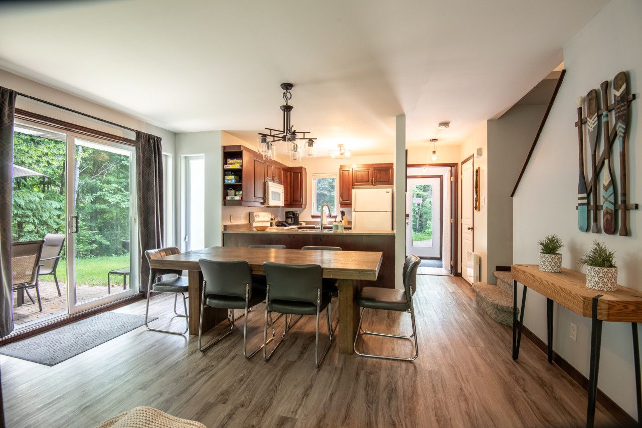 A modern kitchen with a central island, wooden cabinets, and a sliding glass door leading to a patio.