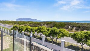Una carretera costera con vista al mar y montañas a lo lejos.