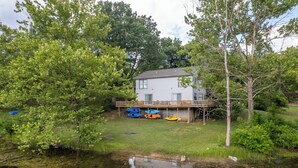 A house with a deck and kayaks. - Kayaks-Lakefront Home - Kiwanie Lodge West (Hardy)