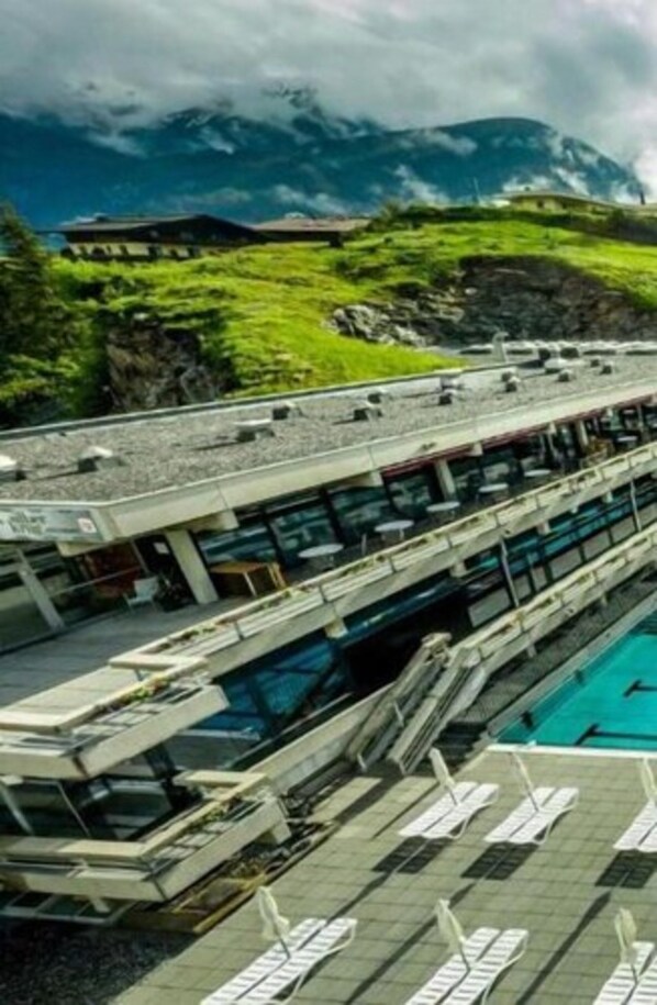 A modern hotel with a pool area, a restaurant, and a view of mountains. - Das Schider Aparthotel Bad Gastein (Bad Gastein)