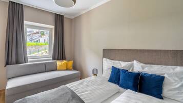 Una habitación de hotel con cama, sofá y ventana con cortinas.