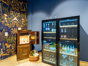 A display of various bottles and a vintage cabinet with a decorative wall mural. - Das Schider Aparthotel Bad Gastein (Bad Gastein)