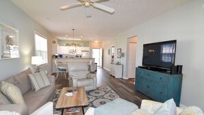 A spacious living room with a sofa, armchairs, a coffee table, and a television on a cabinet. - 3 night minimum.  2 bedroom. Outdoor pool. Close to beach. (North Myrtle Beach)