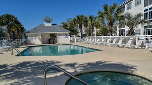 A pool area with lounge chairs, a lifeguard station, and palm trees. - 3 night minimum.  2 bedroom. Outdoor pool. Close to beach. (North Myrtle Beach)