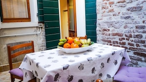 A table with a fruit bowl, a chair, and a tablecloth with owl patterns. - Ca'Marin-Canal view and private patio (Venezia)