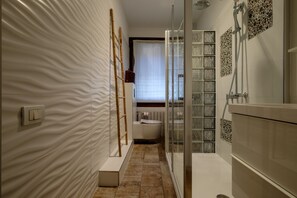 Tina con regadera, secadora de cabello, bidet, toallas 