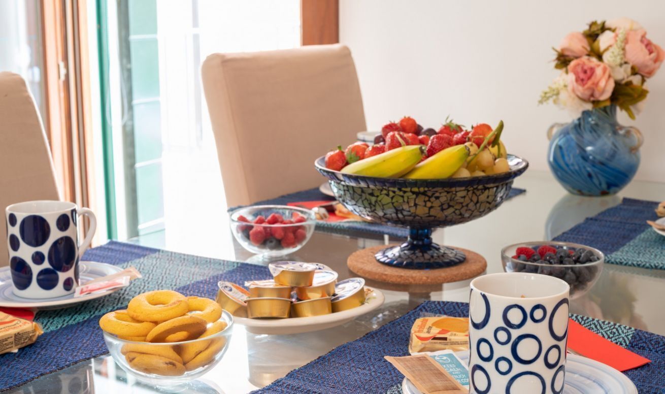Ein Esstisch mit Obstschale, Tasse und verschiedenen Snacks.