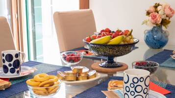 Ein Esstisch mit Obstschale, Tasse und verschiedenen Snacks.