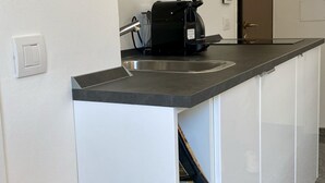 A kitchen with a stainless steel sink, a black coffee maker, and a white cabinet. - Santa Maria Formosa-Sunny Terrace! Near Rialto and St.Mark's (Venezia)