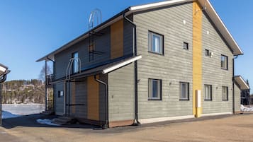 En tvåvåningsbyggnad med en balkong, en garageport och ett tydligt synligt nummer ”B” på sidan.
