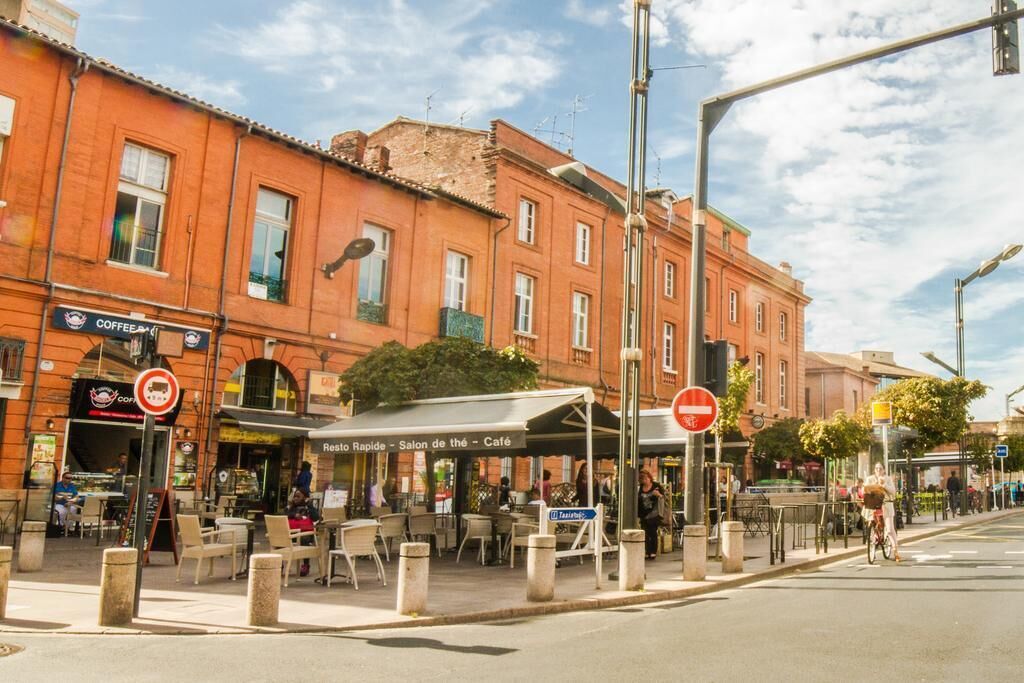 Straatbeeld met een café, terras en een verboden toegangsbord.