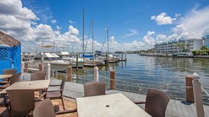 Ein Yachthafen mit vor Anker liegenden Booten, ein Restaurant mit Außenbereich und ein Hotel im Hintergrund.