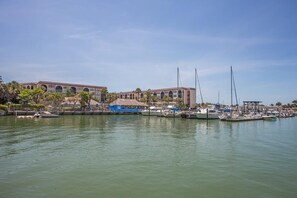 A marina with boats docked, a building with arched windows, and a thatched-roof structure. - Waterfront 1BR condo on Marco Island with pool, WiFi, kitchen and marina access. (Marco Island)