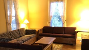 Ein Wohnzimmer mit zwei Sofas, einem Holztisch und zwei Lampen.
