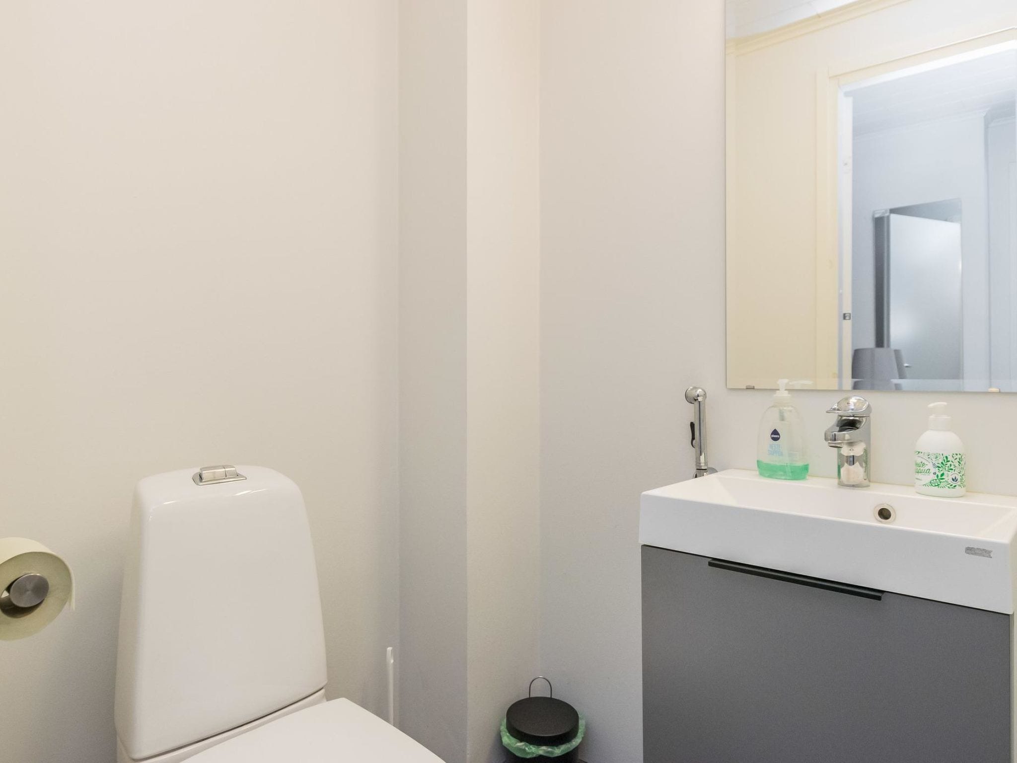 Une salle de bain avec des toilettes, un lavabo et un miroir.