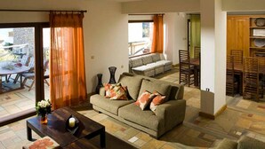 A cozy living room with a sofa, coffee table, and dining area. - Beautiful 3-bed Sea Front Villa in Agios Nikolaos (Agios Nikolaos)