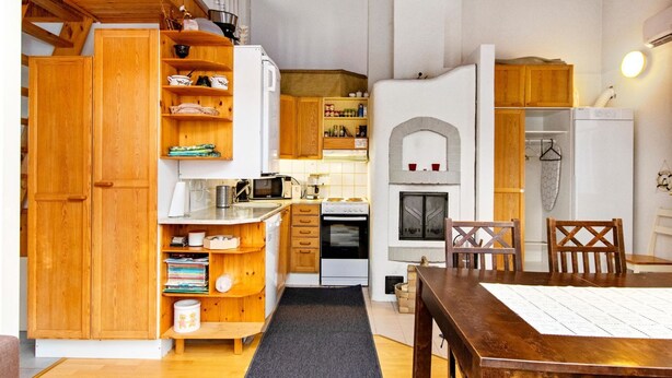 A compact kitchen with wooden cabinets, a microwave, and a stove.
