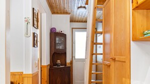 A narrow hallway with wooden walls and a wooden door at the end.