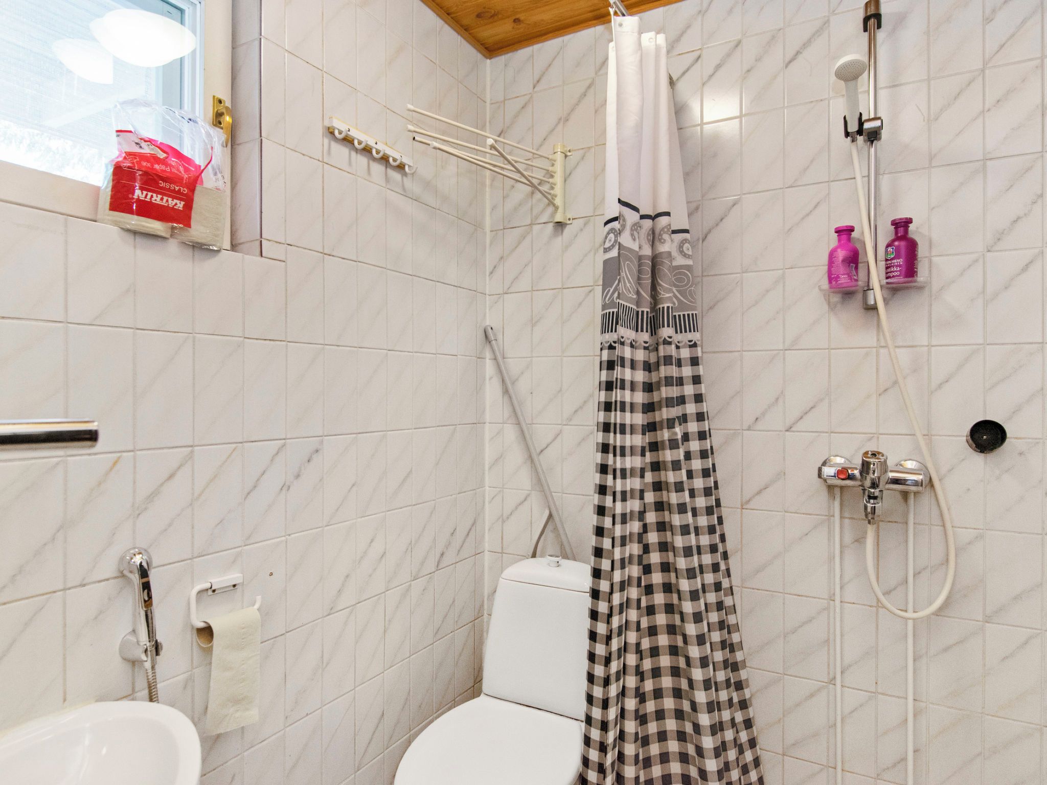 Une salle de bain avec douche, toilettes et lavabo.