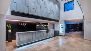 Eine moderne Hotelhalle mit einer Rezeption, einer Bar und einem Essbereich.