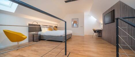 Un apartamento moderno con dormitorio tipo loft, comedor y sala de estar.