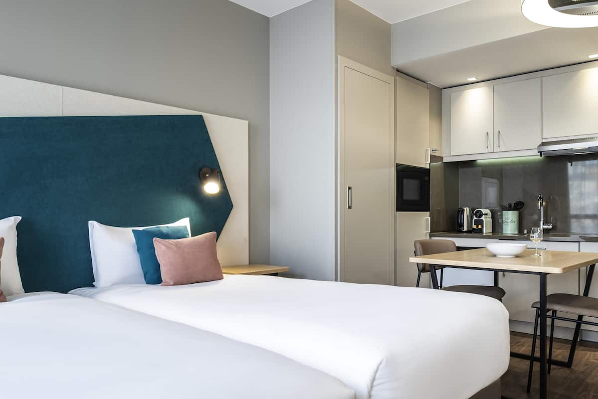 Une chambre d’hôtel avec un lit, un bureau et une kitchenette.