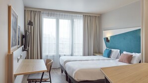 Una habitación de hotel con dos camas, un escritorio y una silla.