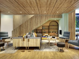 Un interior moderno con techo de madera, un sofá modular, una mesa de centro y una estantería.