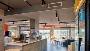 Un espace d’accueil moderne comprenant un comptoir, un ordinateur et un coin salon.