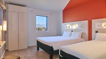 Habitación familiar, varias camas | Colchones con acolchado adicional y cortinas opacas