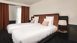 A hotel room with a large bed, a bedside table with a lamp, and a view of the hallway. - Mercure Bordeaux Centre Gare Atlantic (Bordeaux)